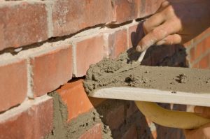 Adv Masonry performing tuckpointing Naperville IL with matched mortar replacement on brick wall
