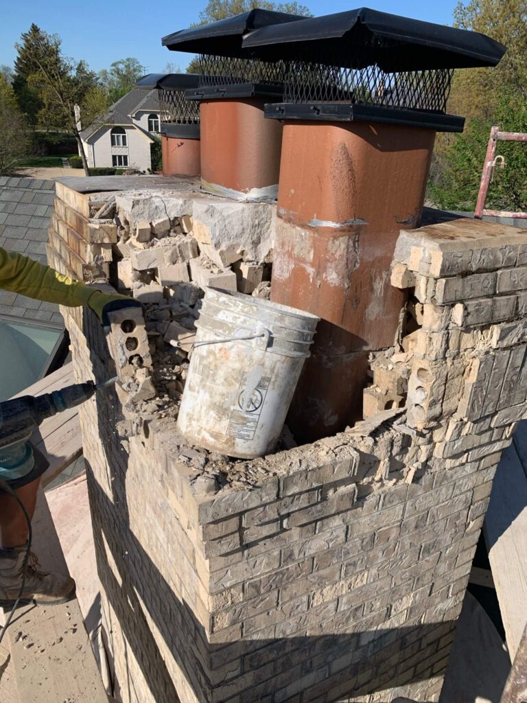 Adv Masonry mason performing chimney repair Naperville during brick removal for chimney rebuild