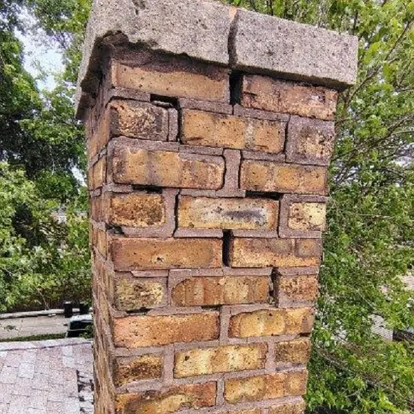 Leaning chimney with cracked brick joints and damaged crown, needing chimney repair Naperville area