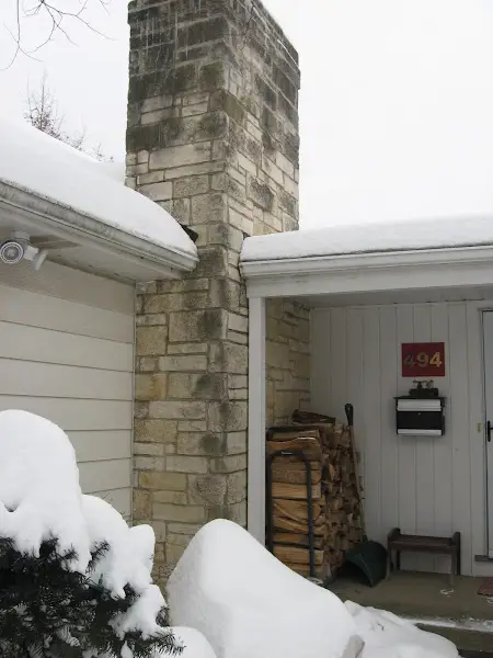 Stone chimney before masonry restoration by ADV Masonry at a Naperville home.